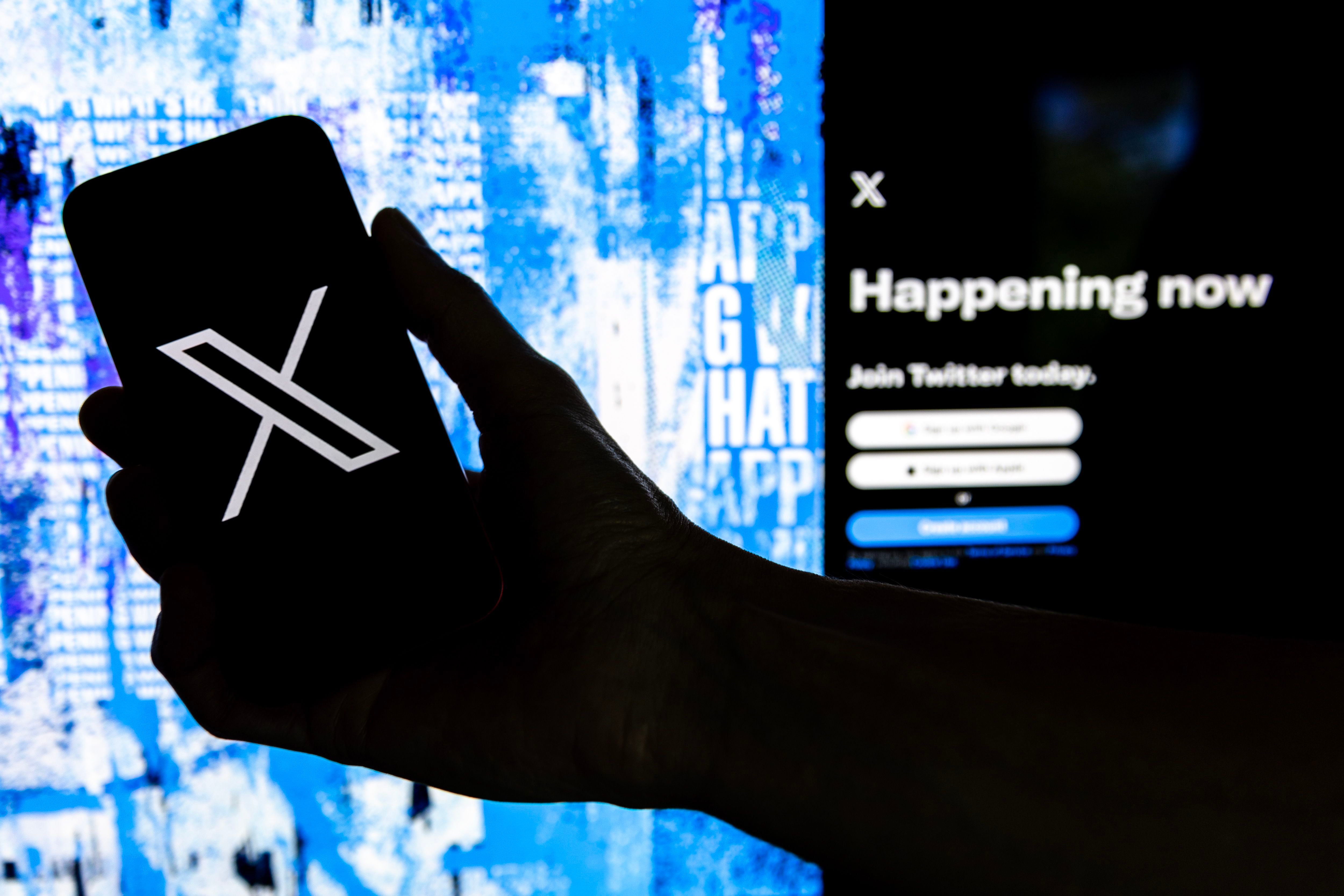 Fotografía de archivo que muestra un usuario mientras sostiene un teléfono móvil que muestra el logotipo 'X'. EFE/EPA/ETIENNE LAURENT 